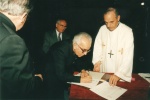 O Pe. Pedro assina o termo de Lançamento da Pedra Fundamental da Igreja do Sagrado Coração de Jesus. 2000. Fotógrafo desconhecido.